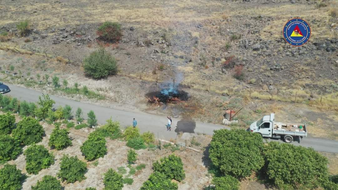 SCORDIA, ACCENDONO UN FUOCO,  MA ALLA VISTA DEL DRONE  CORRONO A SPEGNERLO, ALZANDO LE MANI IN SEGNO DI RESA.